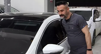 Kaporta ustası, araçları doktor kıyafeti giyerek tamir ediyor
