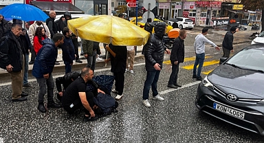 Esnaf, kazada yaralanan yaya ıslanmasın diye şemsiye açtı, üstüne mont örttü